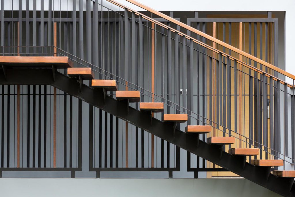 Holztreppe mit Geländer aus Metall sowie Holz